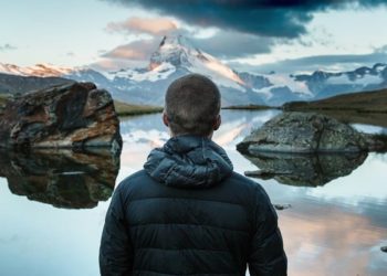 man in front of mountain lake